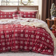 a bed with red and white snowflakes on it, next to a window