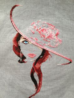 a close up of a woman's face wearing a hat with roses on it