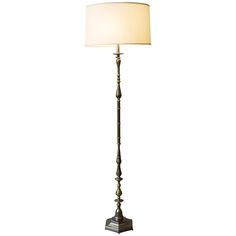 a floor lamp with a white shade on it