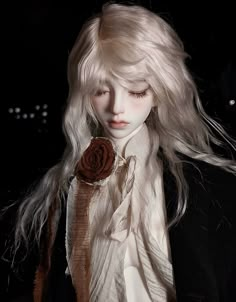 a doll with long white hair and a rose in its lapel, wearing a black jacket