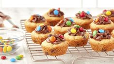 cupcakes with chocolate frosting and m & m candies on a cooling rack