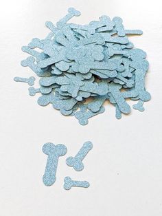 a pile of blue glittered dog tags on top of a white table