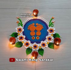 an intricately decorated diya with flowers and candles on the floor for diwaling