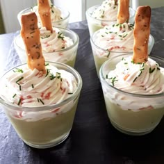 four small cups filled with whipped cream and crackers