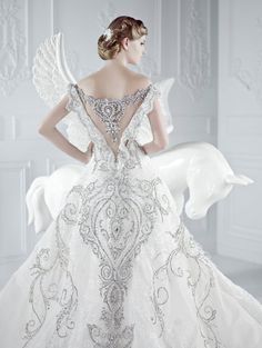 a woman in a wedding dress with an angel on her back