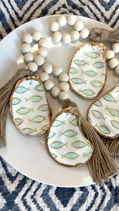 some white eggs and tassels are on a plate with blue and white designs