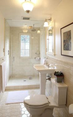 a bathroom with a toilet, sink and shower