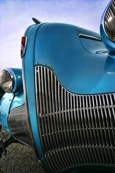 the front end of an old blue car