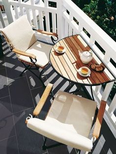 two chairs and a table on a balcony