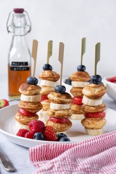 mini pancakes with berries and blueberries are arranged on a plate