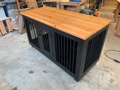 a large wooden table sitting inside of a room next to other woodworking tools and supplies