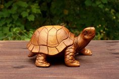 a small wooden turtle sitting on top of a wooden table