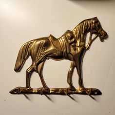 a golden horse statue is hanging on the wall