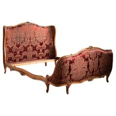 an ornately decorated bed with red velvet upholstered headboard