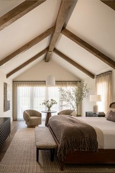 a large bed sitting under a wooden beam in a bedroom