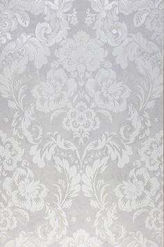 a white and grey wallpaper with flowers on the bottom right hand corner in an ornate pattern