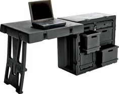 a laptop computer sitting on top of a black table with drawers underneath it and an open drawer below