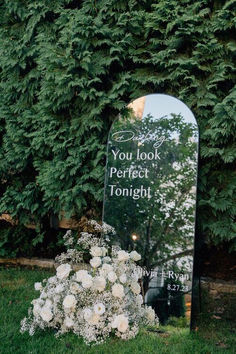 a memorial in the grass with flowers and a sign that says you look perfect tonight