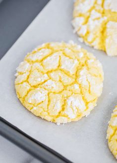 three cookies with powdered sugar are on a baking sheet, ready to be baked