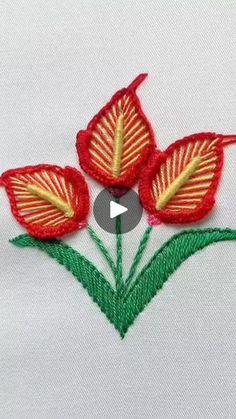 an embroidered red flower with green leaves is shown on a white shirt that has the words,