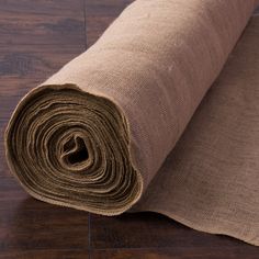 a roll of burlock on the floor next to a piece of fabric that has been rolled down