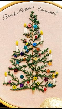 a cross stitch christmas tree with buttons on it