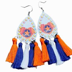 three pairs of earrings with tassels and beads on the bottom, one has an orange