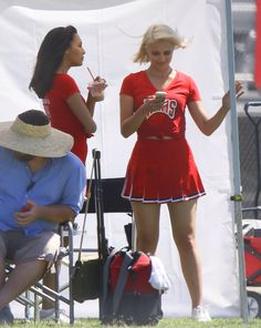 a woman in a red dress standing next to a man