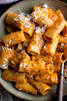 a bowl filled with pasta covered in sauce and parmesan cheese