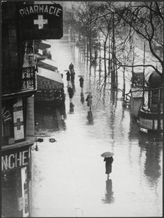 black and white photograph of people walking in the rain