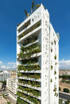 a tall white building with plants growing on it