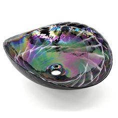 a glass bowl shaped like a fish on top of a white surface with colorful swirls