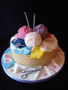 there is a cake decorated with yarn and knitting needles