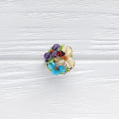 This romantic Glass ladybug flower ring is a perfect gift for women. It's very tender and unique! Set Matching bracelet: https://www.etsy.com/listing/161559547 Matching earrings: https://www.etsy.com/listing/200833152 Matching pendant: https://www.etsy.com/listing/161556072 Dimensions: the ring is adjustable. The bead is 2.2-2.4cm in diameter. Materials: artist lampwork bead, metal fittings. Colors used: blue, white, lilac, violet, green. Please, note, each bead is made by hand and may differ sl Multicolor Flower Ring For Wedding, Flower Shaped Birthstone Ring, Multicolor Flower Ring As Gift, Multicolor Flower Ring Gift, Adjustable Multicolor Flower Ring, Handmade Flower Ring Perfect For Spring Gift, Adjustable Flower Charm Ring, Adjustable Flower Shaped Ring Perfect For Gift, Multicolor Flower-shaped Rings For Spring