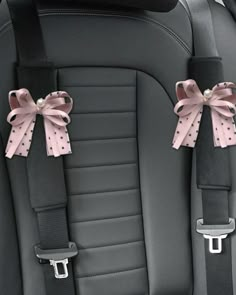 two pink bows are attached to the back of a car seat