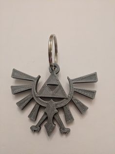 a keychain with an image of a bird on it's face and two arrows in the middle