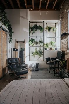 a bedroom with lots of plants on the window sill, and a bed in front of it