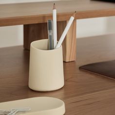 two pencils in a cup on a table