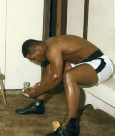 a man squatting on the floor with his foot up