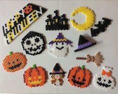 halloween beaded decorations are arranged on a white surface with pumpkins, ghost, jack - o'- lantern and other items