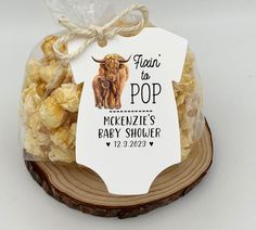 there is a bag of popcorn in the shape of a cow on top of a wooden slice