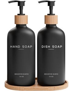 two black soap dispensers on a wooden tray with the words dish soap