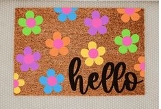 a door mat with the word hello written on it and colorful flowers all over it