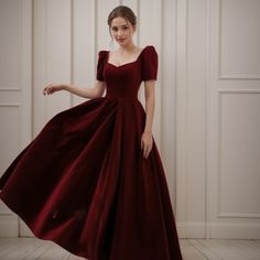 a woman in a red dress posing for the camera with her hand on her hip