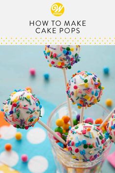 cake pops with sprinkles in a glass vase on a blue tablecloth