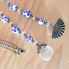 a necklace with blue and white beads on it sitting on top of a wooden table