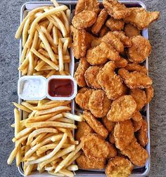 chicken wings, french fries and ketchup on a tray with dipping sauces