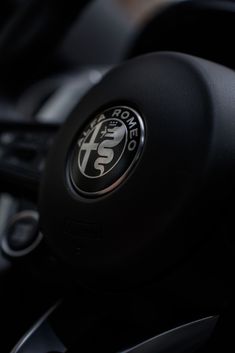 the steering wheel and center console of a car with an emblem on it's dashboard