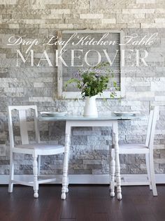 a white table and two chairs in front of a brick wall with words above it