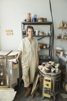 a woman standing in front of some pottery